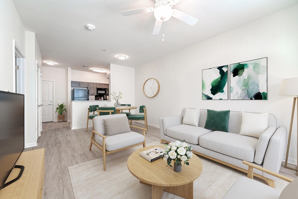 A living room with a white couch, a wooden coffee table, and a ceiling fan.