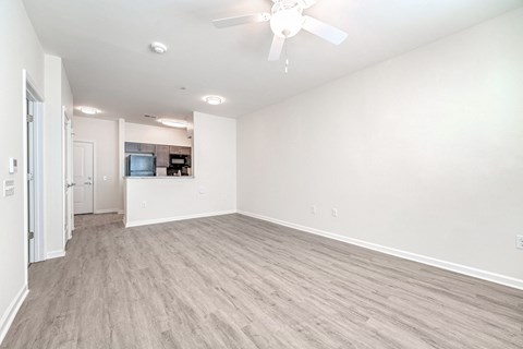 A spacious room with a ceiling fan and lighting fixtures.