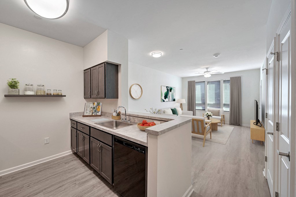 A modern kitchen with dark brown cabinets and a white countertop.