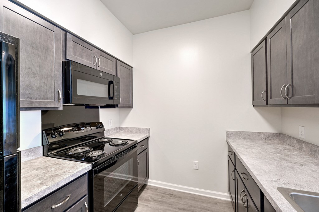 A kitchen with a black stove top oven and microwave.