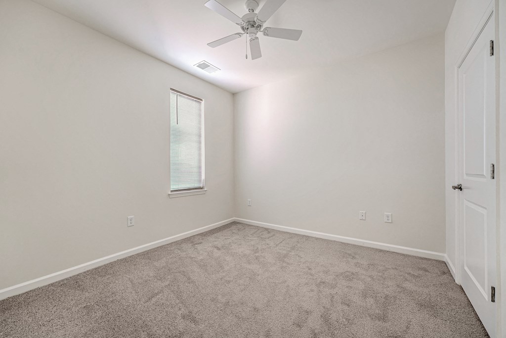 A room with a ceiling fan and a window.