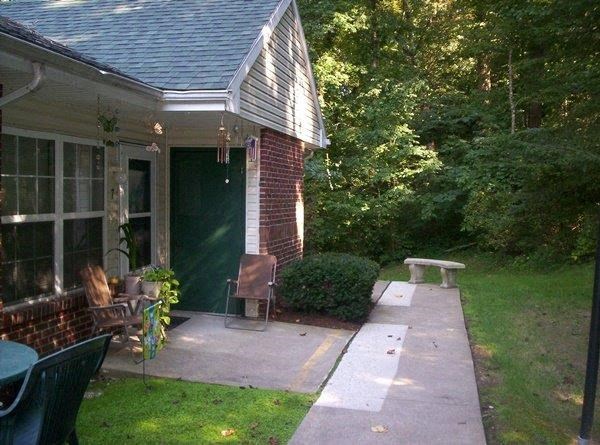 a patio in front of a house with a bench