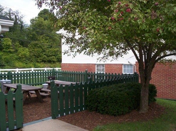 a green picket fence and a picnic table in front of a building
