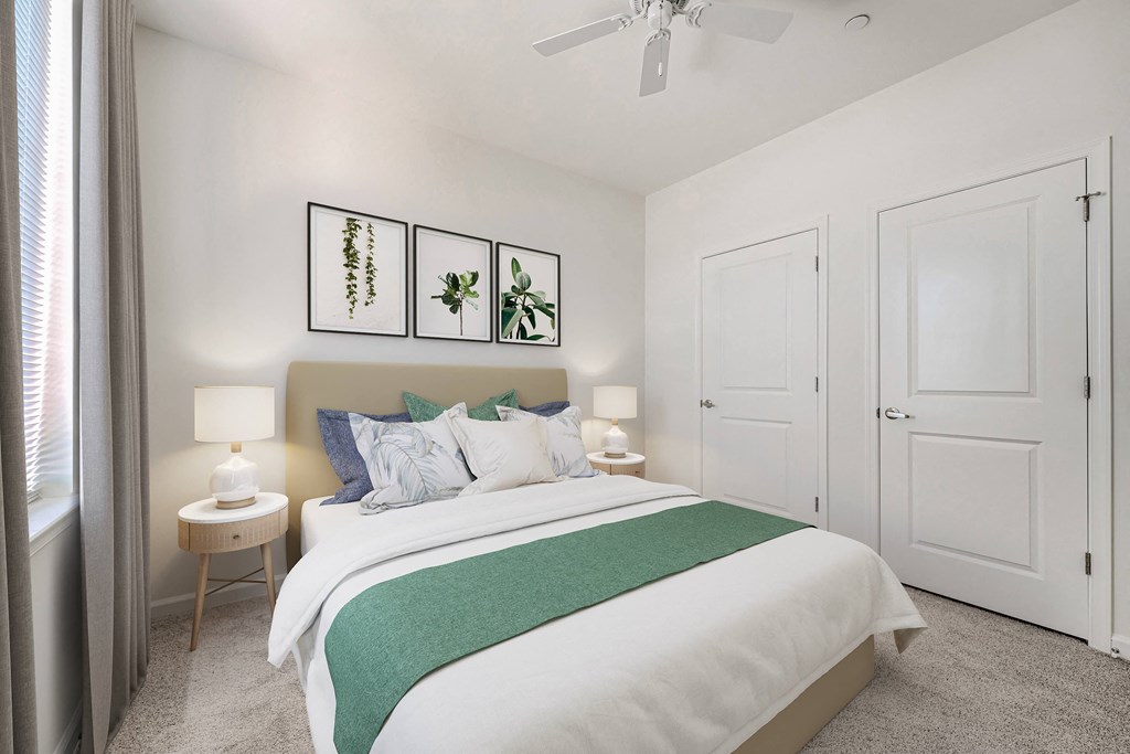 A bedroom with a bed, two lamps, and a ceiling fan.