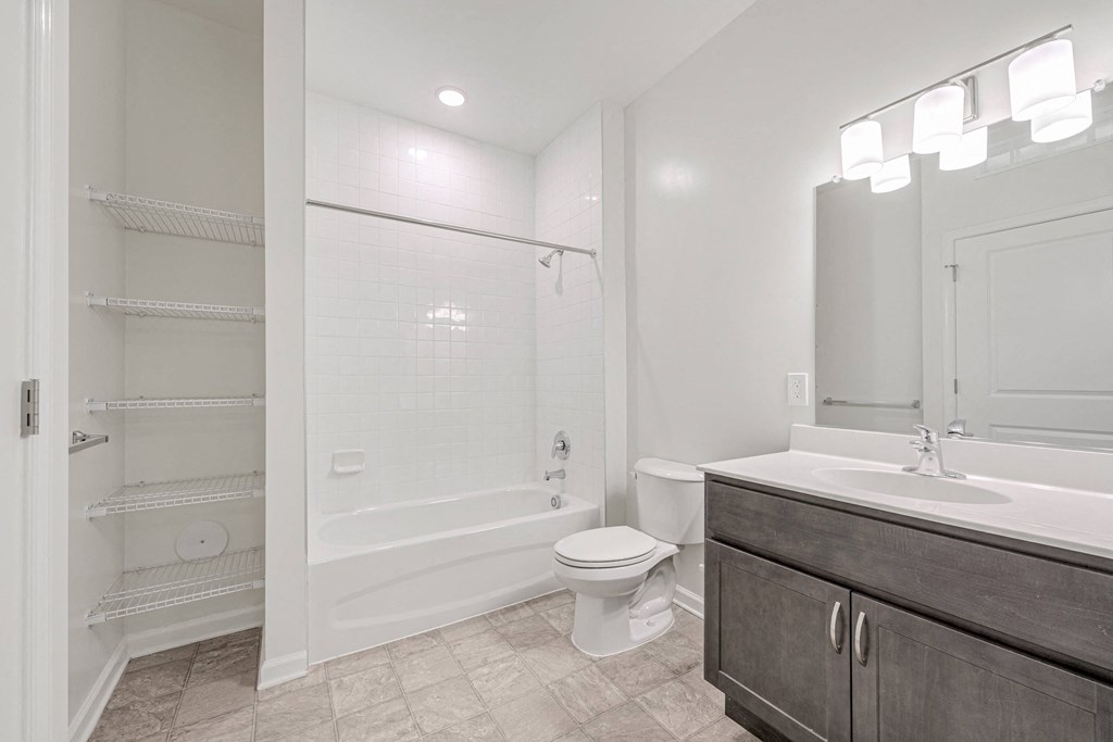A white bathroom with a walk in shower and a toilet.