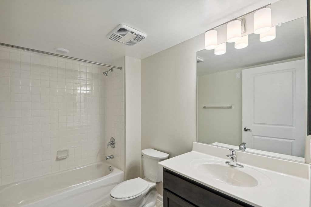 a bathroom with a sink toilet and shower and a mirror