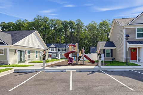 A playground with a slide and a bicycle is in the foreground of a residential area.