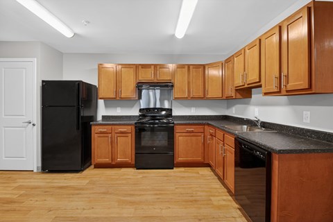 A kitchen with wooden cabinets and black appliances.