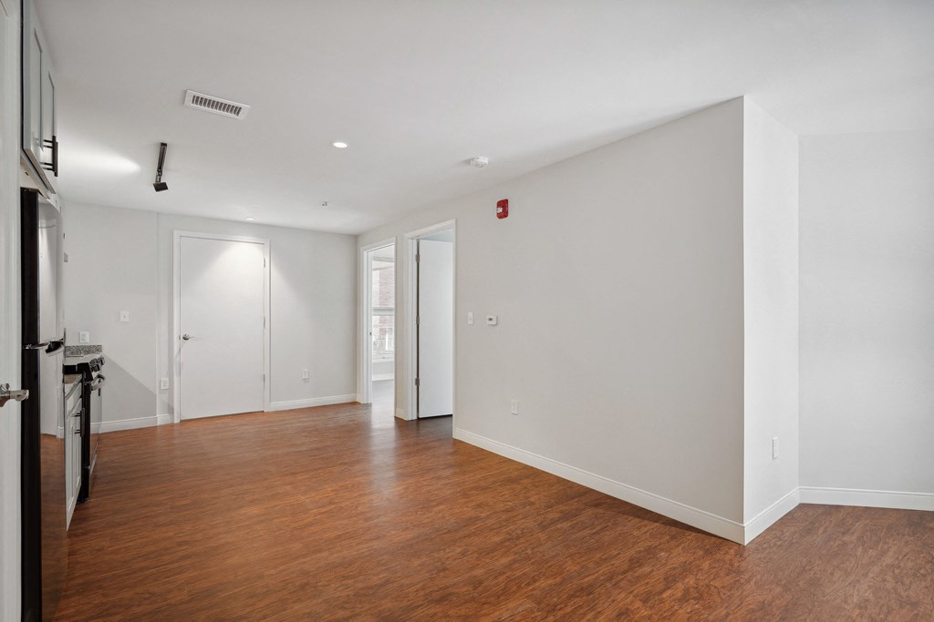 a bedroom with a medium hardwood floor and white walls