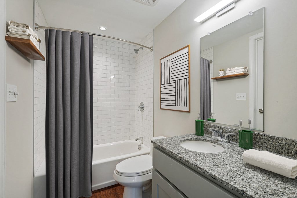 a bathroom with a shower and a sink and a toilet