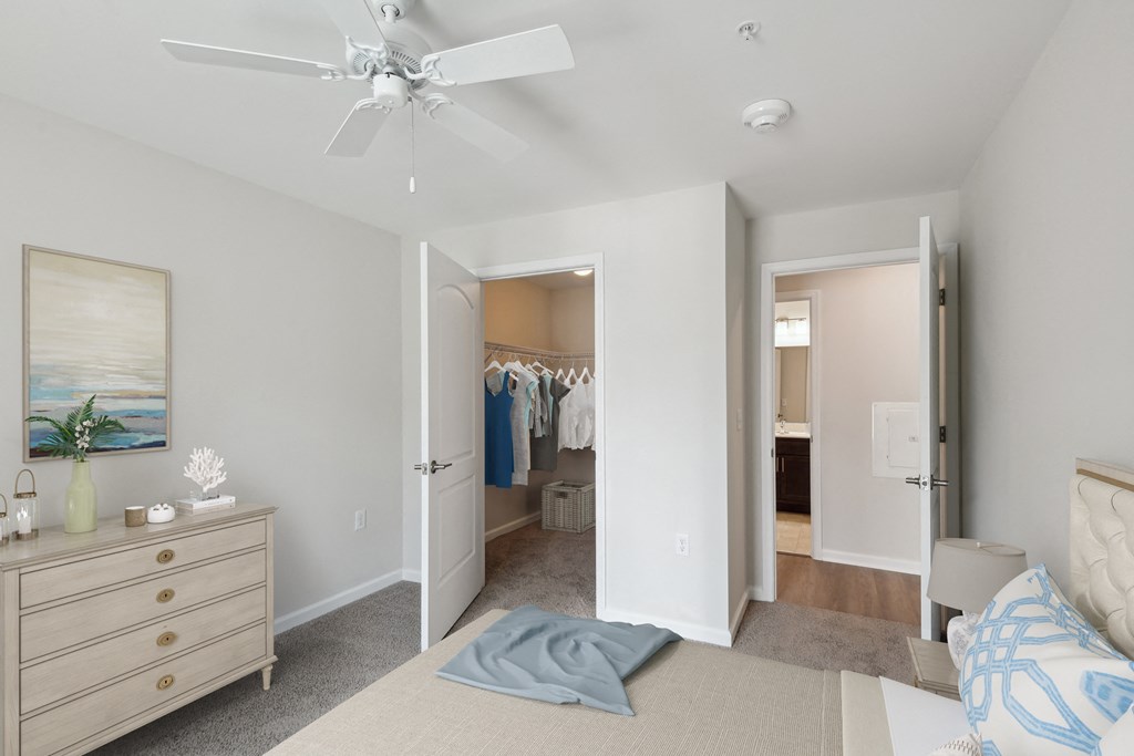 a bedroom with a bed and closet and a ceiling fan