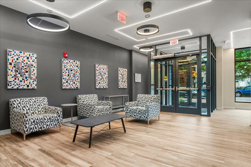 a lobby with chairs and a table and a glass door