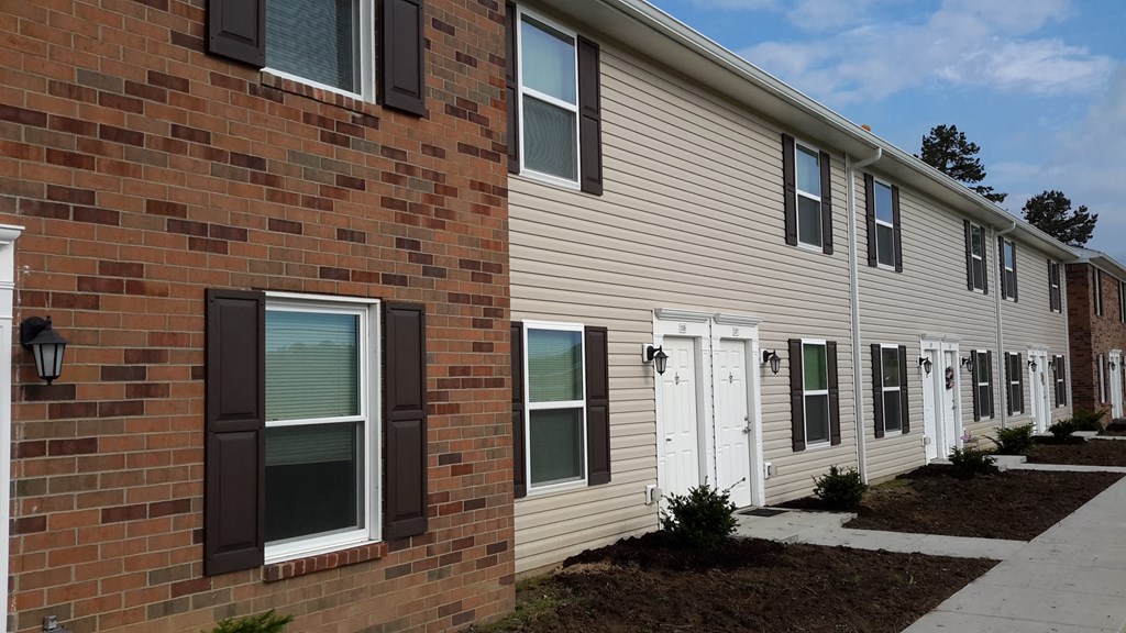 a brick building with a sidewalk in front of it
