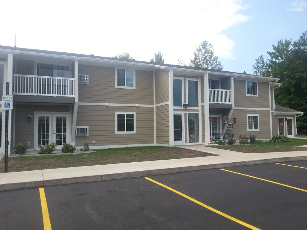 an apartment building with a parking lot in front of it