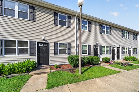 A building with grey siding and black doors.
