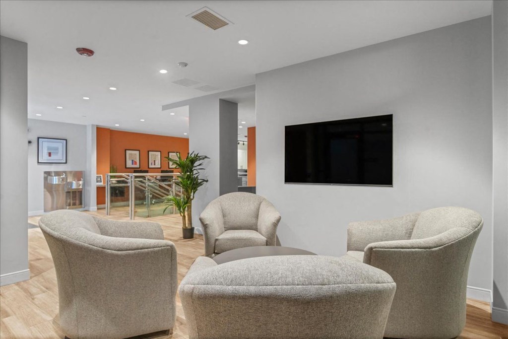 a living room with chairs and a tv