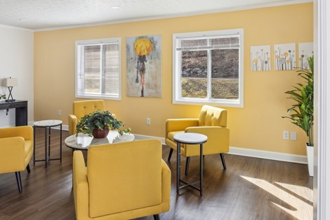 A living room with yellow chairs and a white table.