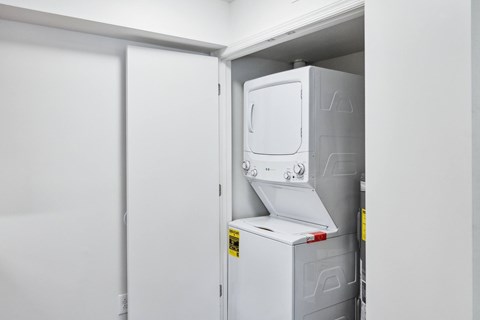 A white refrigerator is installed in a white room.