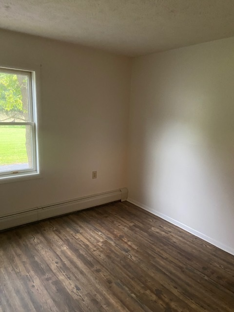 A room with a window and wooden flooring.