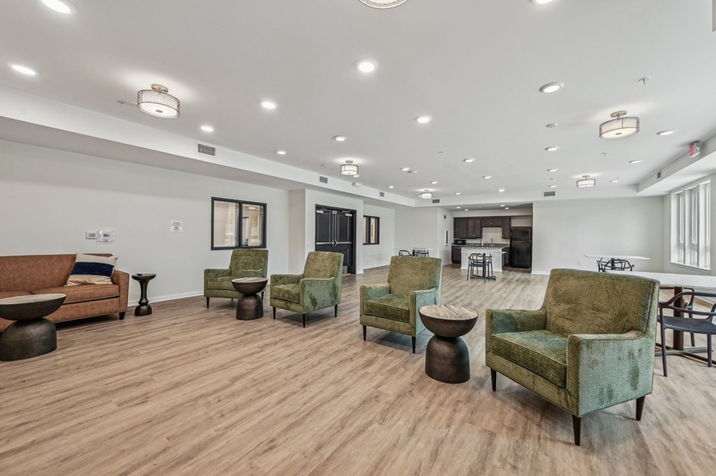 A living room with a green chair and a brown sofa.