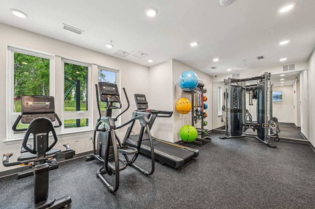 A spacious gym with a variety of equipment including treadmills, exercise bikes, and weight machines.