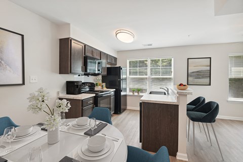 a kitchen and dining room with a white table and chairs and a black