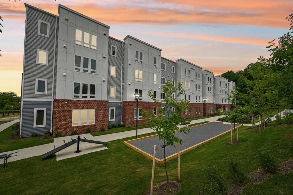 Apartment complex with a walkway in front.