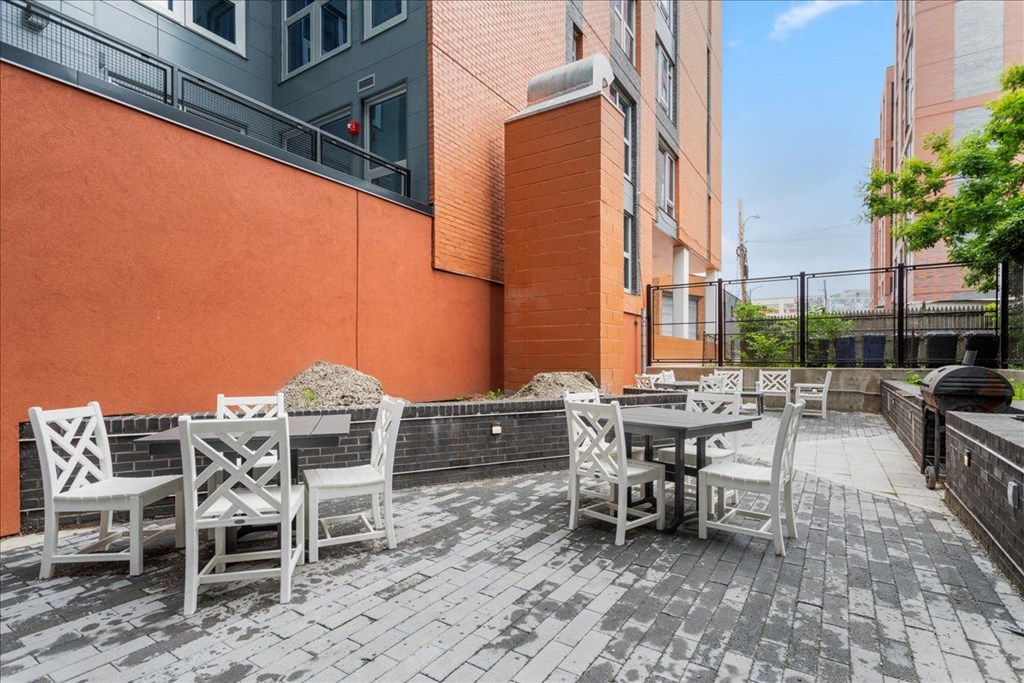a patio with tables and chairs outside of a building