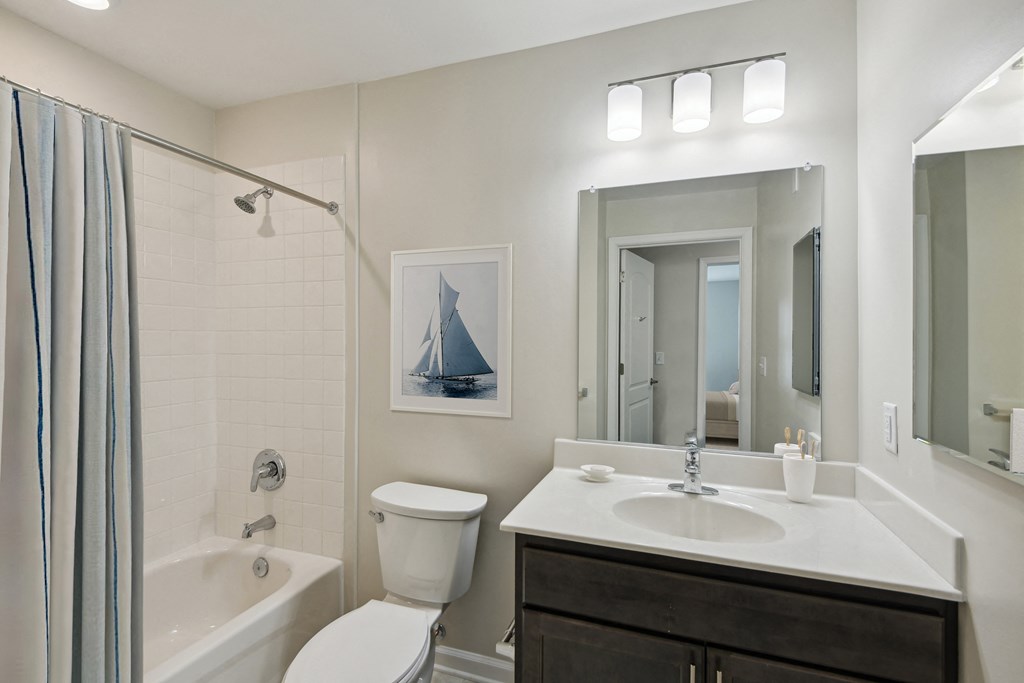 a bathroom with a shower sink and toilet and a mirror