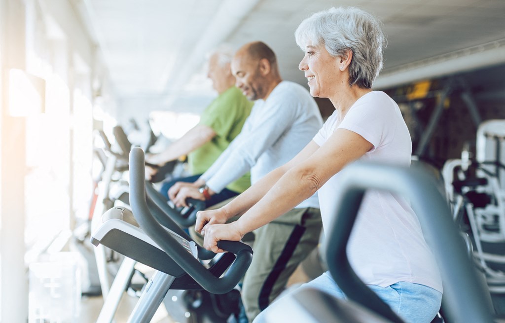 a group of people biking on exercise bikes at a gym