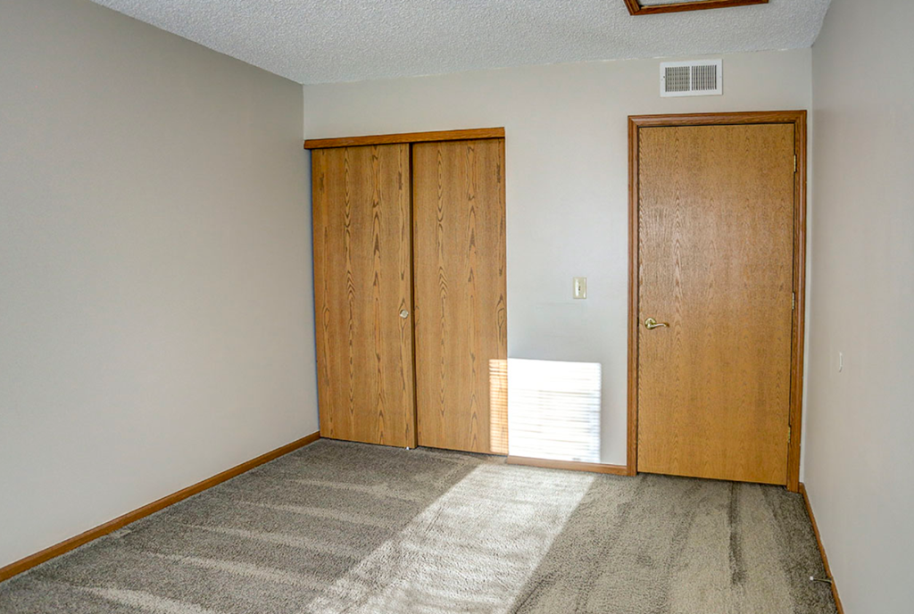 a room with a carpeted floor and a wooden door