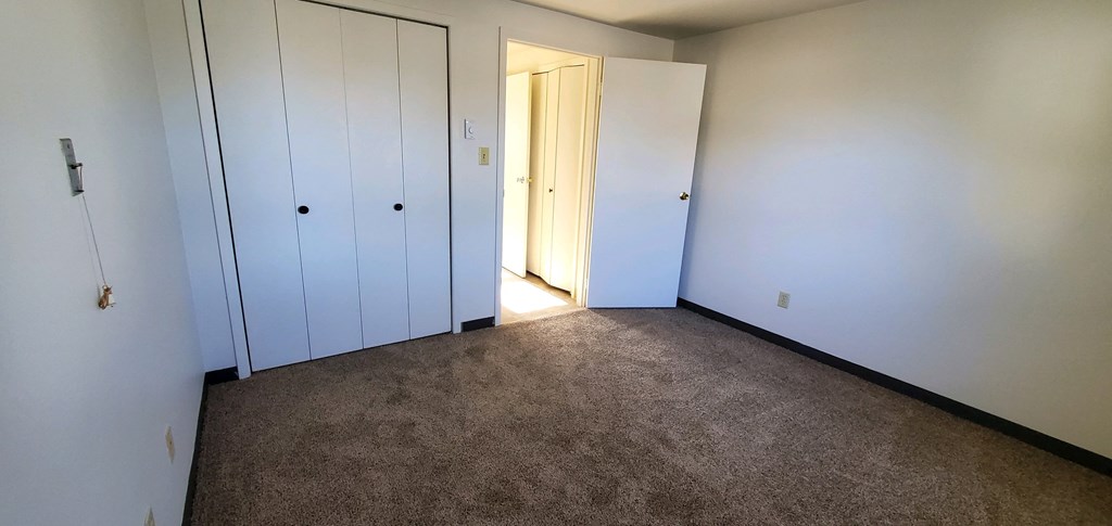 a bedroom with two closets and a door to a hallway