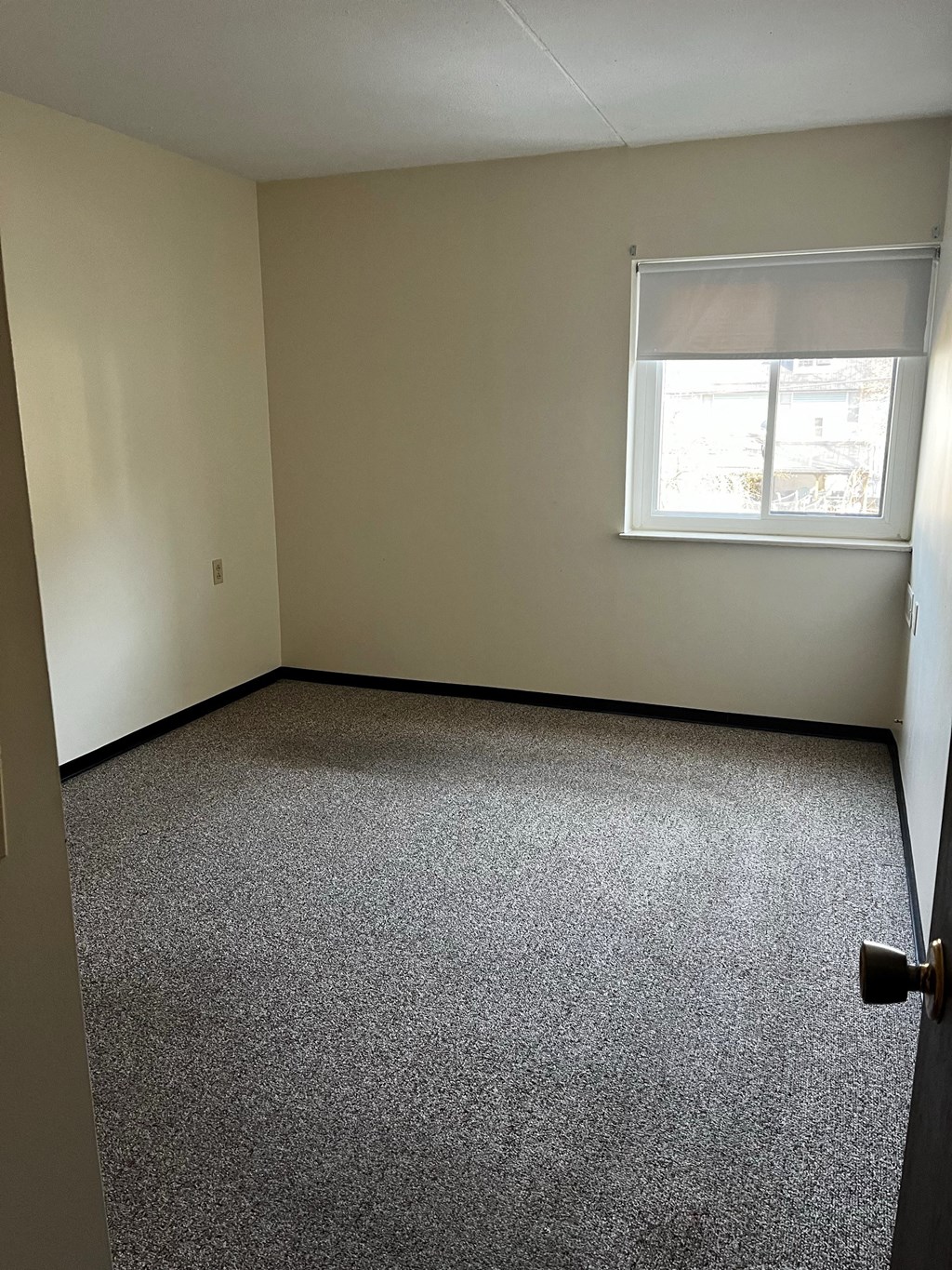 an empty room with carpet and a window