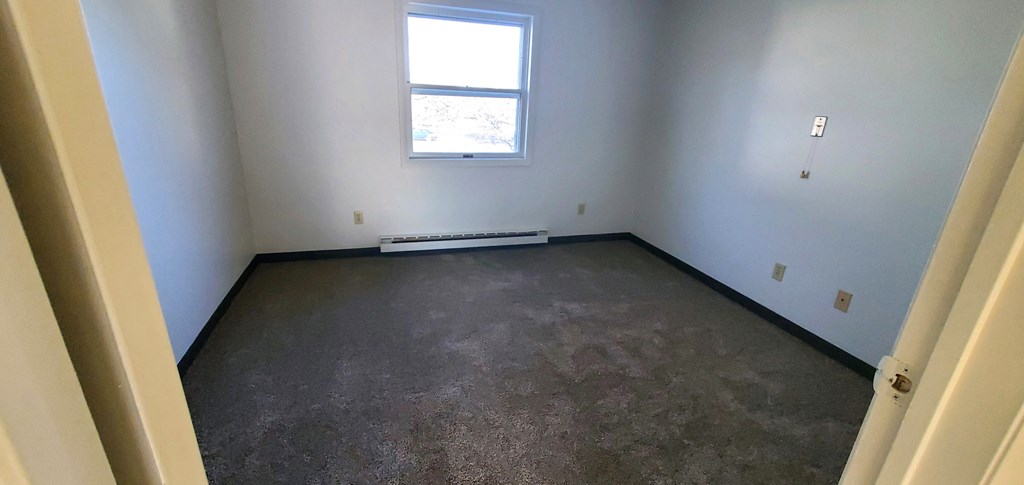 a room with a carpeted floor and a window