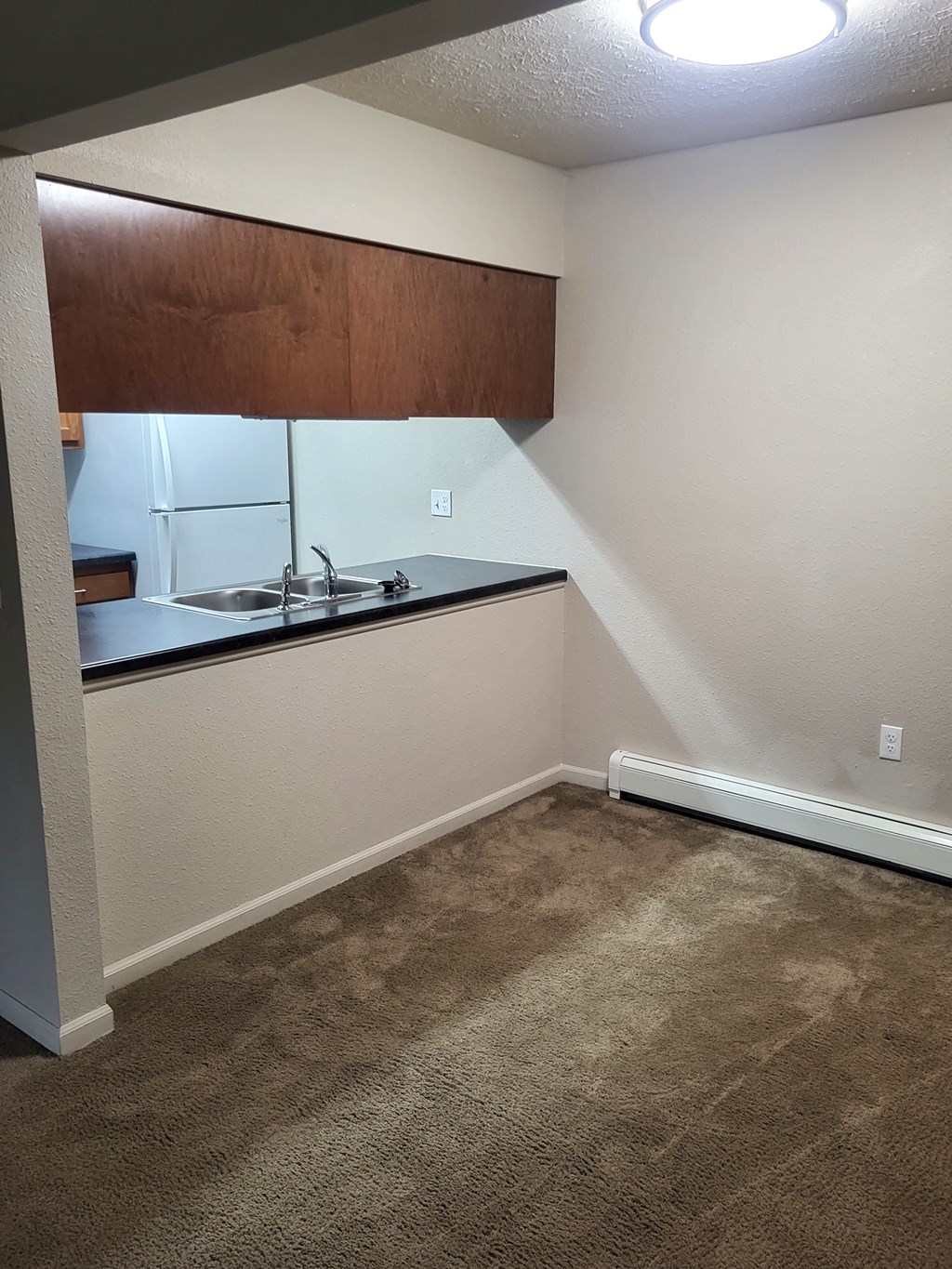dining room with carpet looking into kitchen