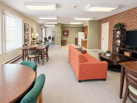 A living room with a couch, chairs, and a television.