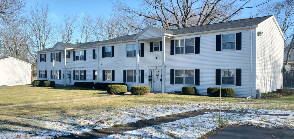 a white house with a yard in the snow