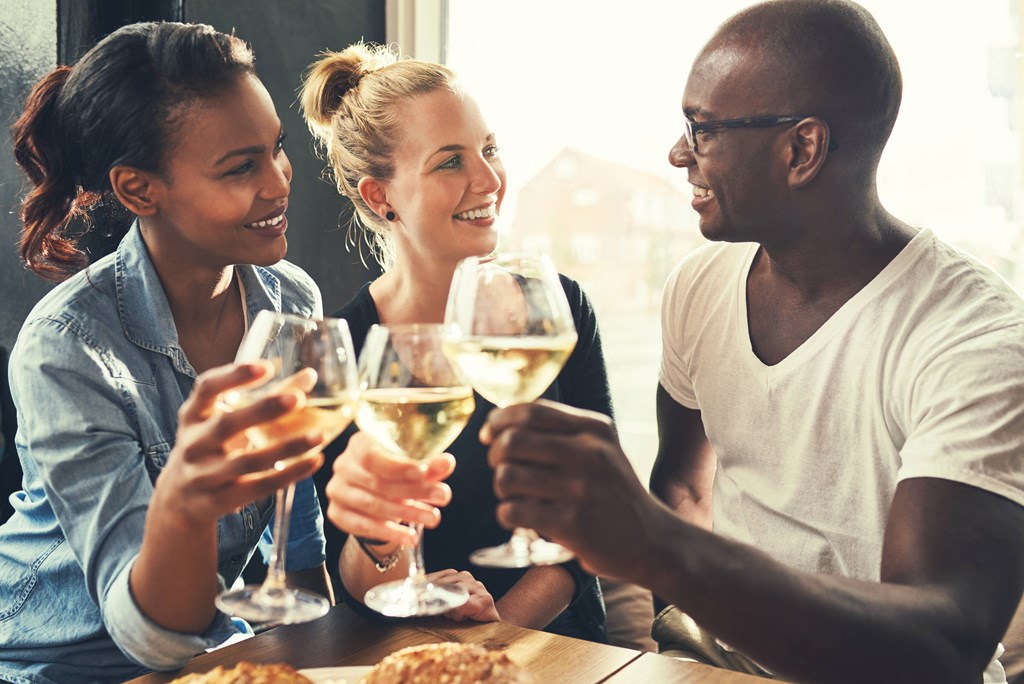 a group of people sitting around a table drinking wine
