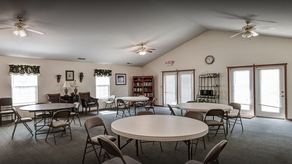 a community room with tables and chairs and ceiling fans