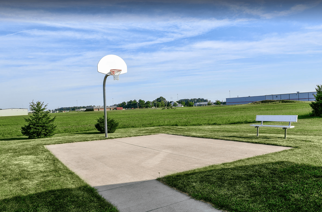 a basketball hoop and a bench in a park