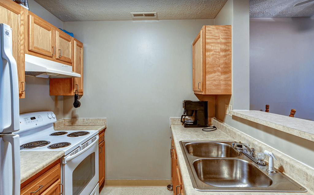 an empty kitchen with a stove sink and refrigerator
