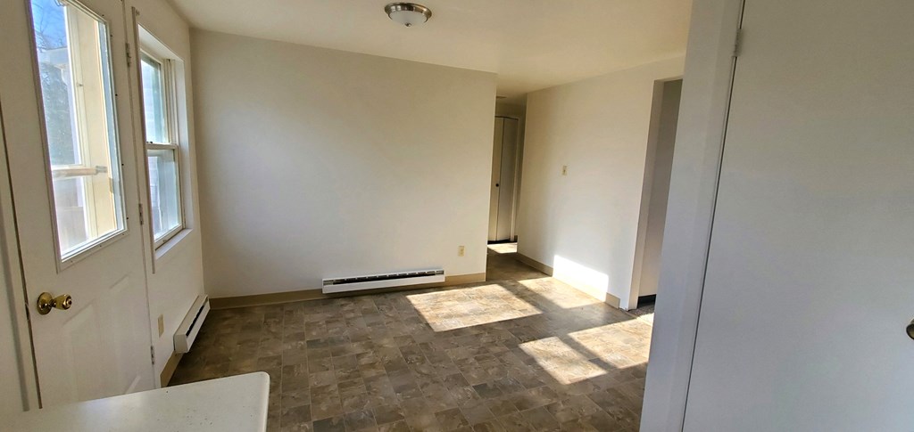 an empty living room with white walls and a window
