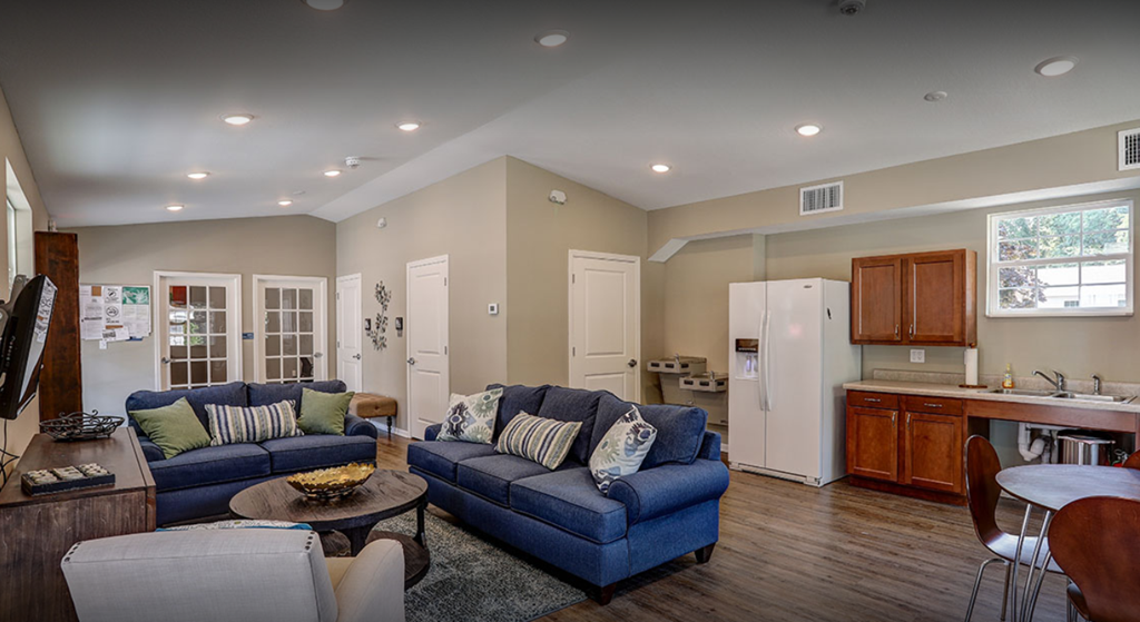 a living room and kitchen with couches and a table