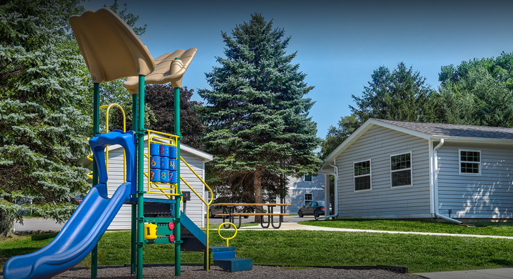 a playground with a slide and a picnic table
