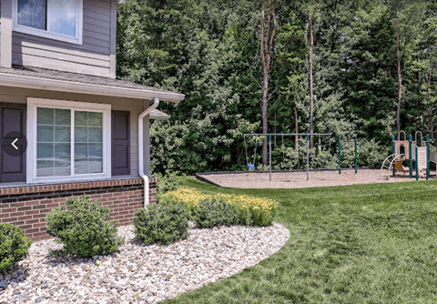a yard with a swing set in front of a house