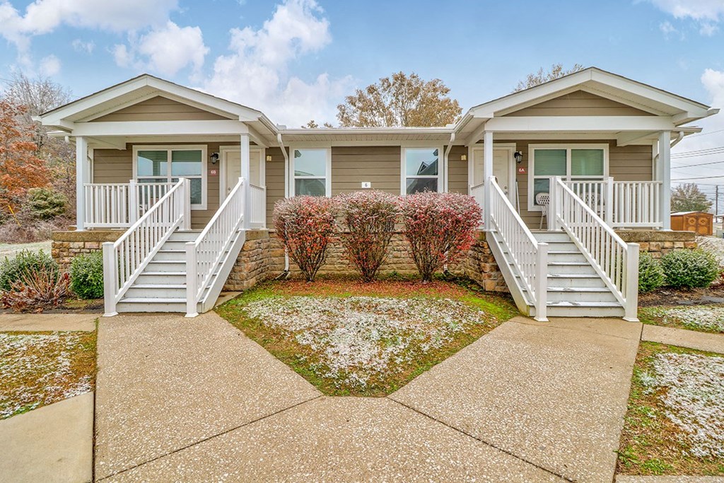 the front of a house with a porch and stairs