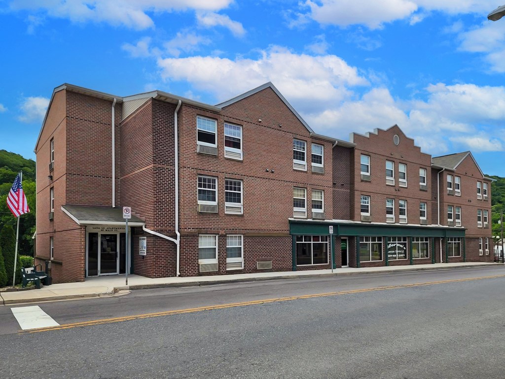 a brick building with an flag in front of a street