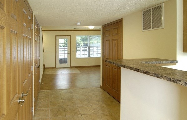 an empty kitchen and living room with a door to a patio