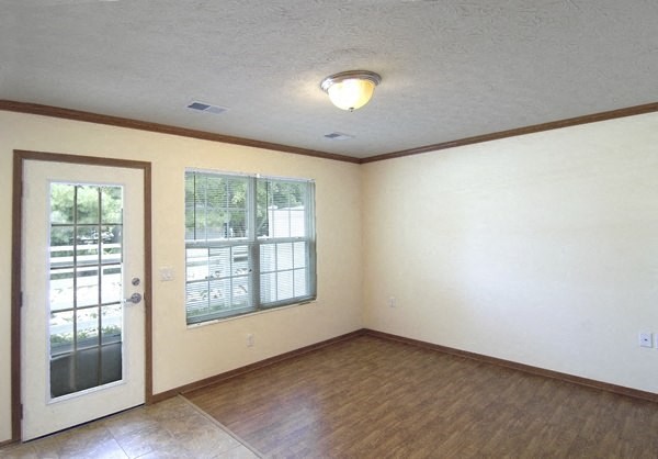 an empty living room with a door and a window
