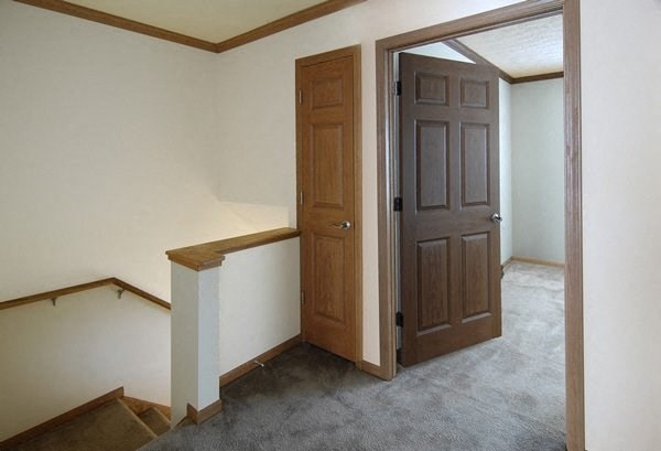 an empty room with a door and stairs in a house